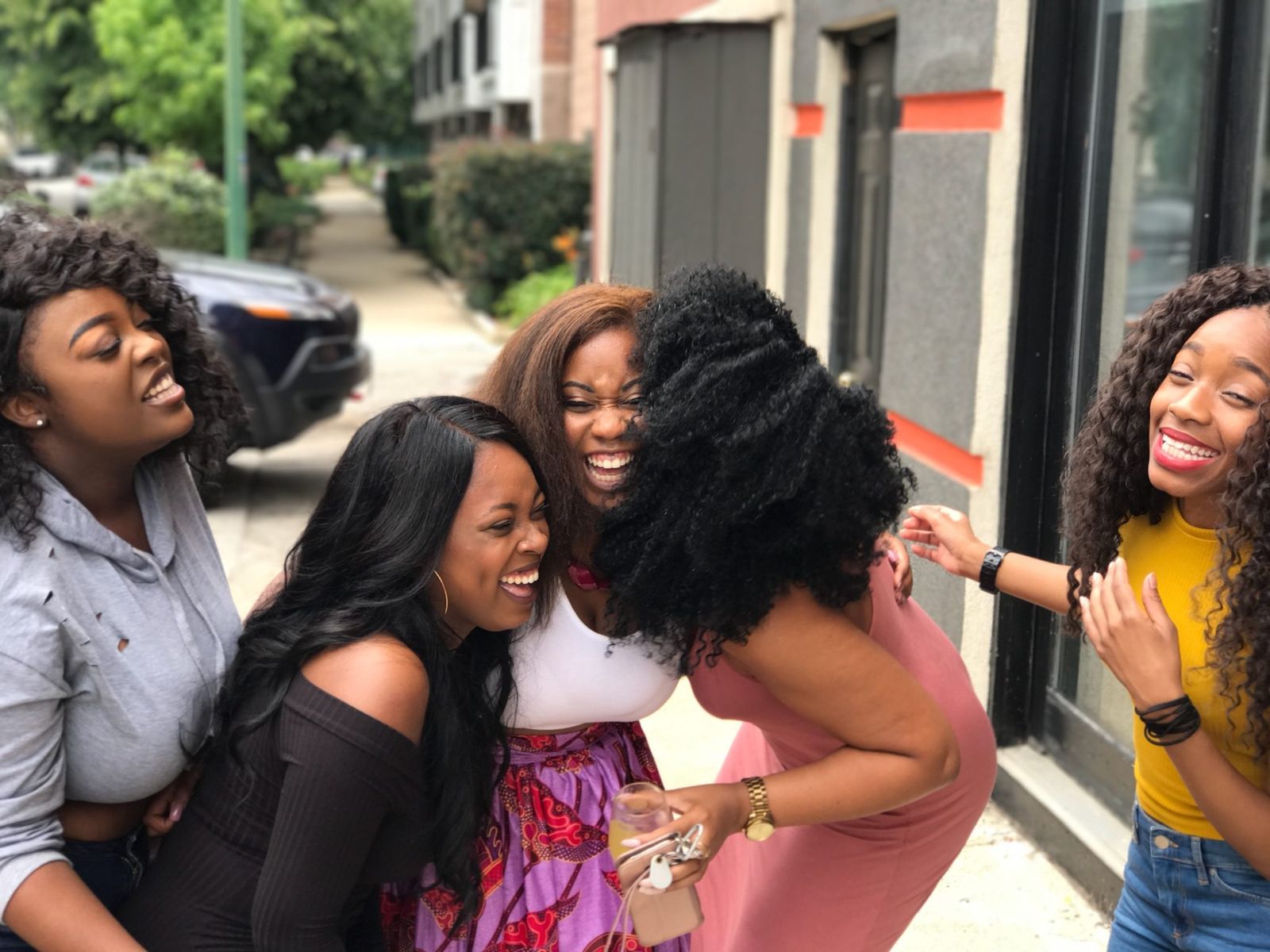 Radiant Black women gathering and laughing together in warm sunlight